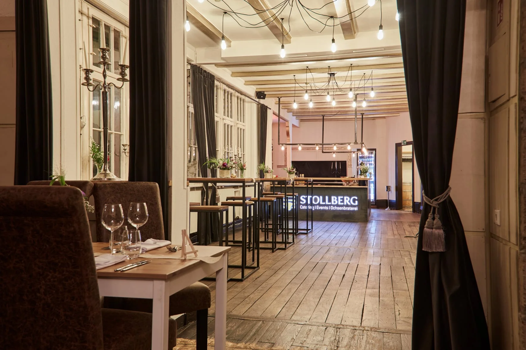 Innenraum der Villa Mediterrane in Bielefeld mit Hochtischen und Barbereich