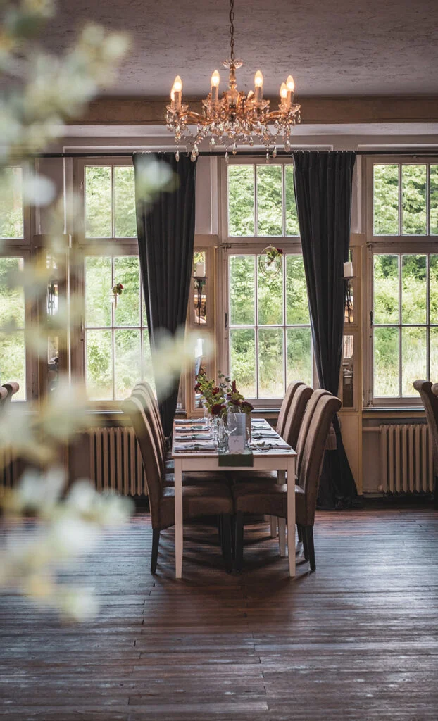 Gedeckter Tisch unter Kronleuchter im Innenraum der Villa Mediterrane in Bielefeld