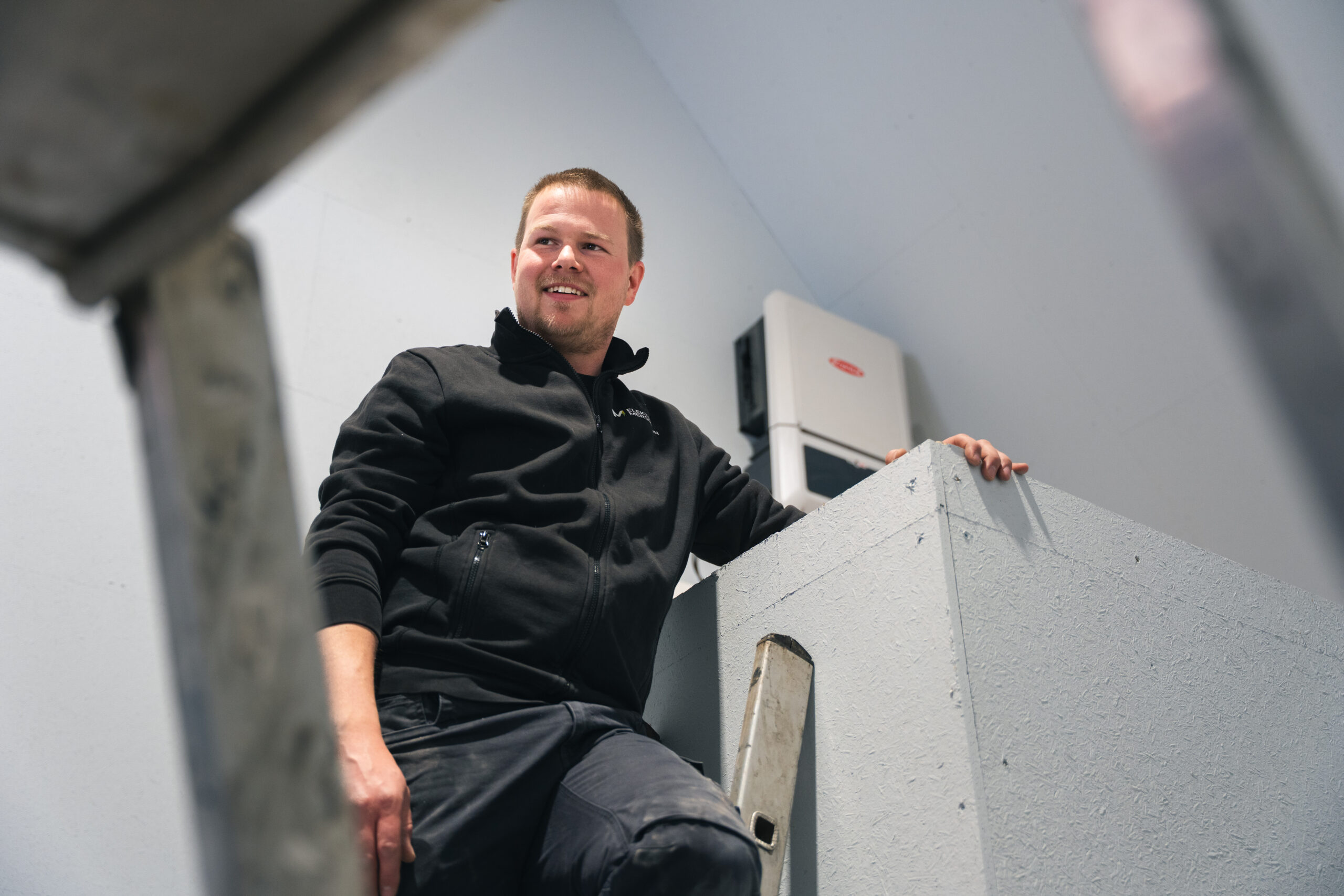Aaron Mersmann von Elektro Mersmann neben einem installierten Fronius Wechselrichter – Photovoltaik-Installation in Harsewinkel