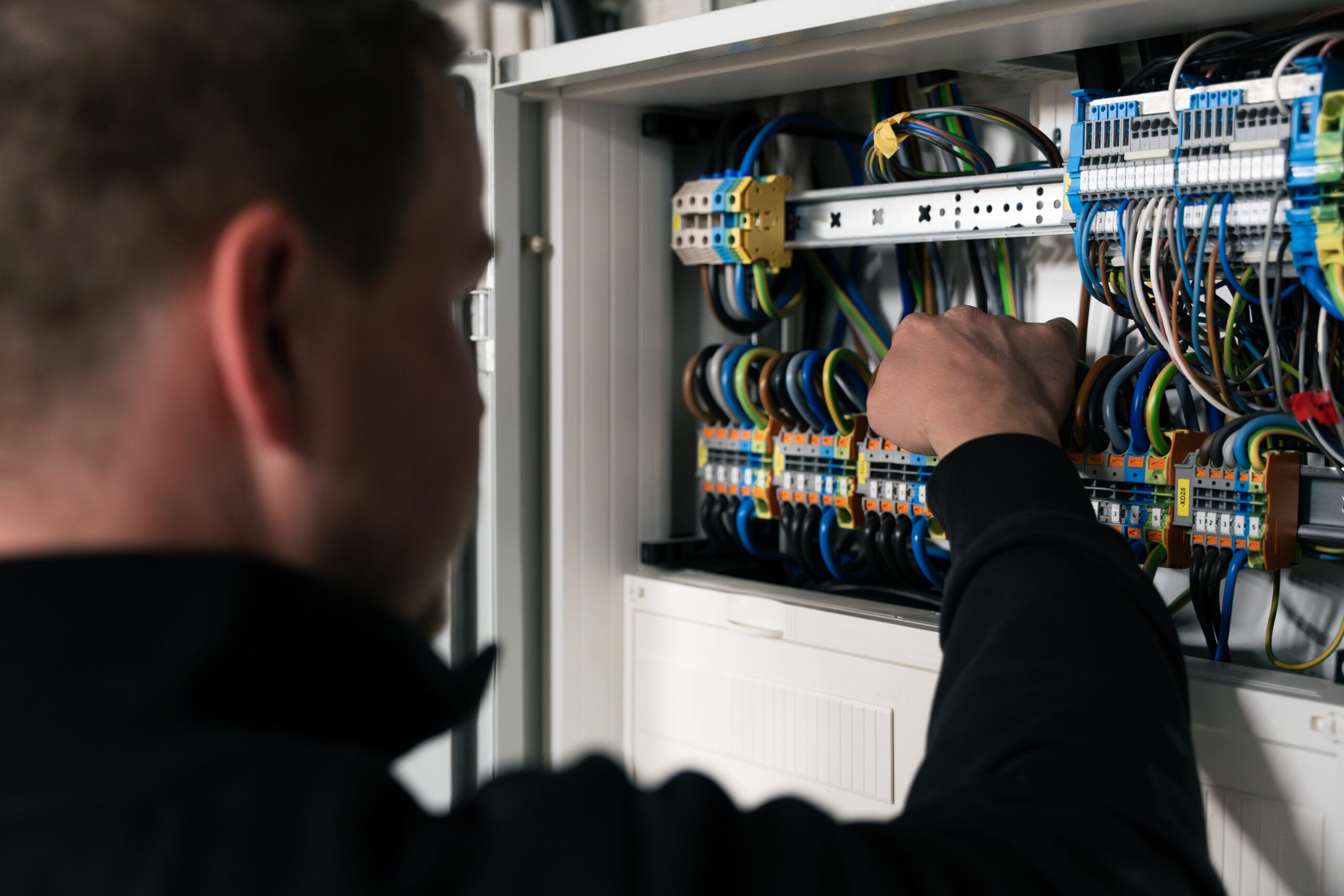 Elektriker von Elektro Mersmann bei der professionellen Verkabelung eines Schaltschranks in Harsewinkel